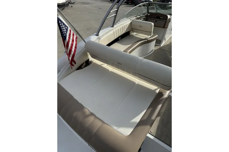 Slide: The Image of 2010 Cobalt 276 boat interior with beige seating and American flag. - 10