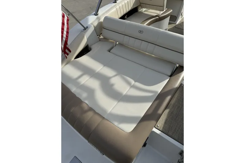 Slide: The Image of 2010 Cobalt 276 boat interior with beige seating and American flag. - 11