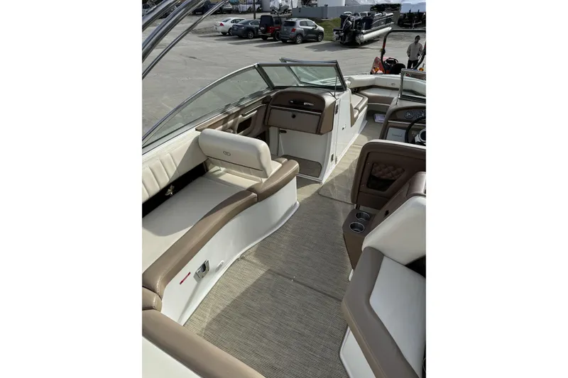 Slide: The Image of 2010 Cobalt 276 boat interior with beige and brown seating, docked in a marina. - 12