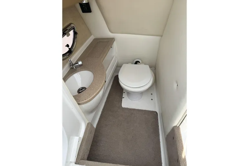 Slide: The Image of 2010 Cobalt 276 boat bathroom with sink, toilet, and carpeted floor. - 22