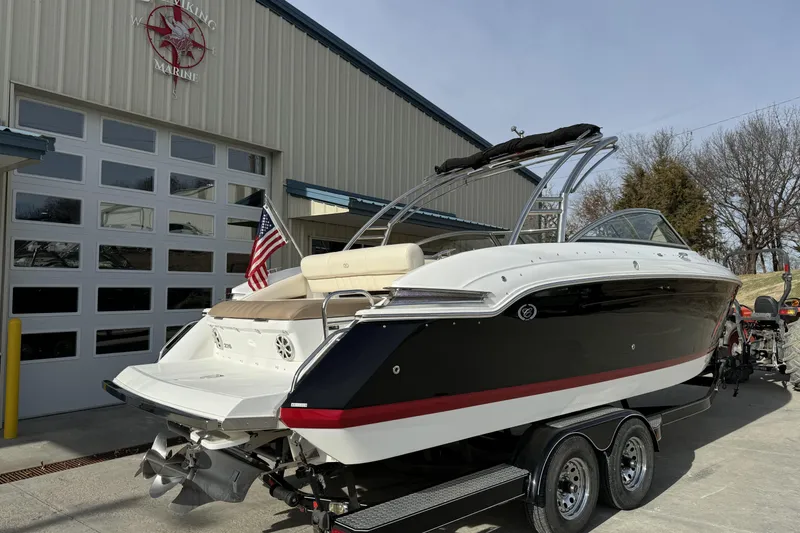 Slide: The Image of 2010 Cobalt 276 boat on trailer outside marine building, American flag displayed. - 3