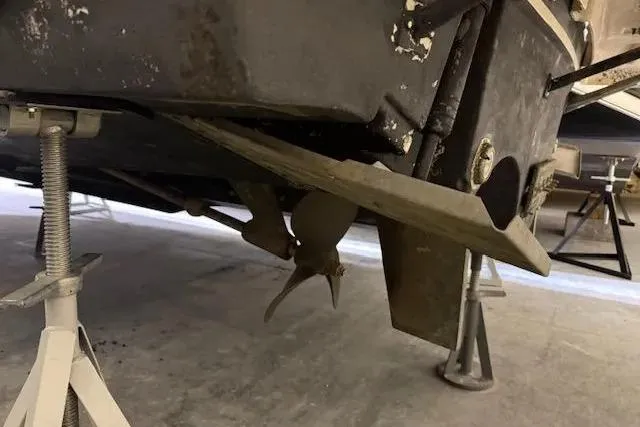 Slide: The Image of 1997 Tiara Yachts 2900 Open boat propeller and hull on stands in a workshop. - 12