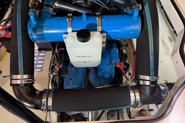 Slide: The Image of Engine compartment of a 1997 Tiara Yachts 2900 Open, featuring blue components and hoses. - 17