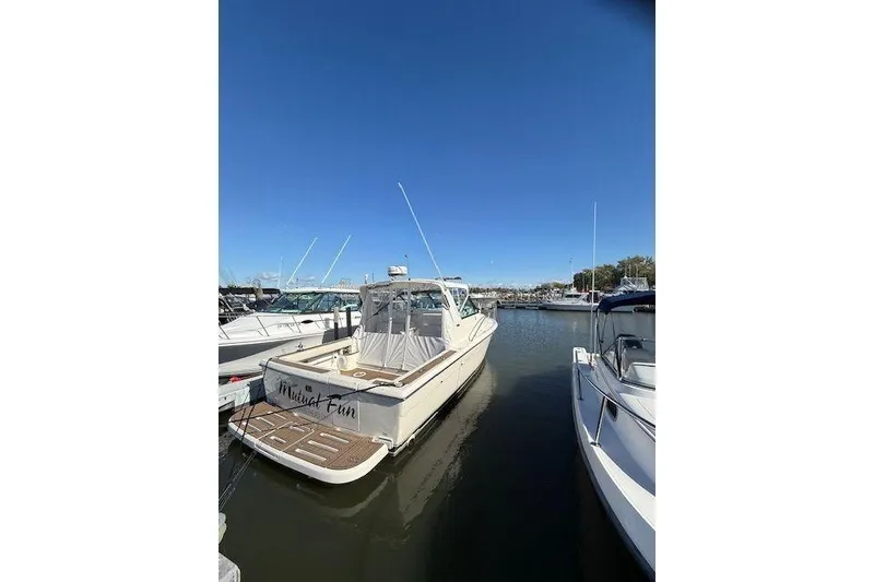 Slide: The Image of 1997 Tiara Yachts 2900 Open docked in a marina under clear blue skies. - 2