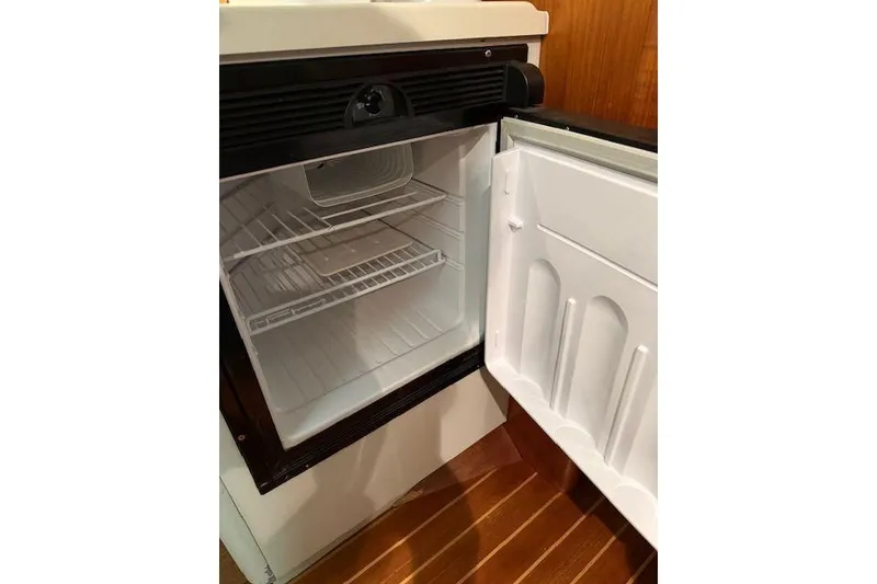 Slide: The Image of Open refrigerator inside 1997 Tiara Yachts 2900 Open, showcasing interior shelves. - 22
