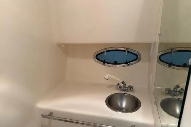 Slide: The Image of 1997 Tiara Yachts 2900 Open bathroom with sink and porthole window. - 23