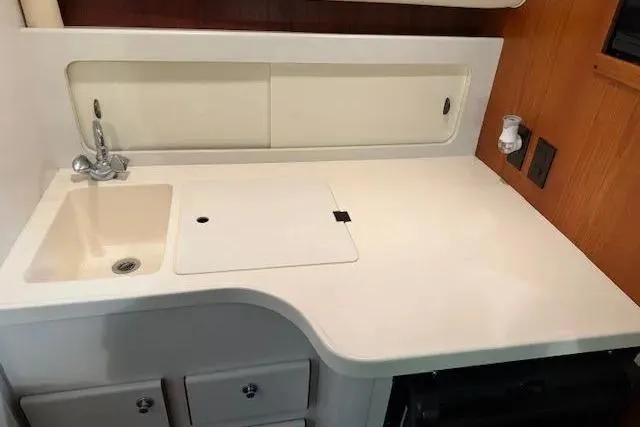 Slide: The Image of 1997 Tiara Yachts 2900 Open galley with sink, countertop, and storage. - 25