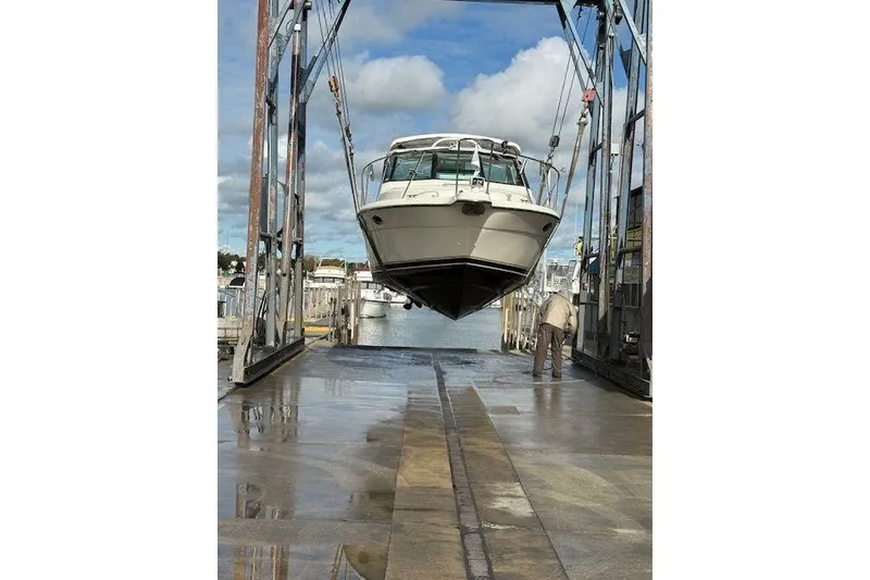 Slide: The Image of 1997 Tiara Yachts 2900 Open being lifted at a marina. - 3