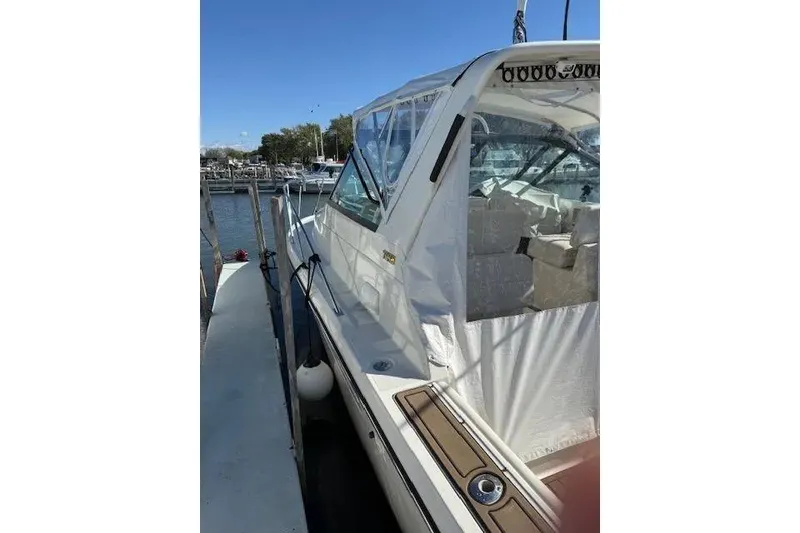 Slide: The Image of 1997 Tiara Yachts 2900 Open docked, featuring clear enclosure and sleek design. - 4