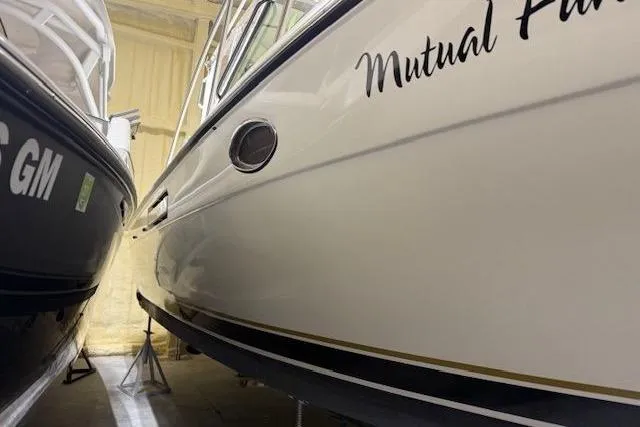 Slide: The Image of 1997 Tiara Yachts 2900 Open boat in storage, side view with name "Mutual Fun." - 6