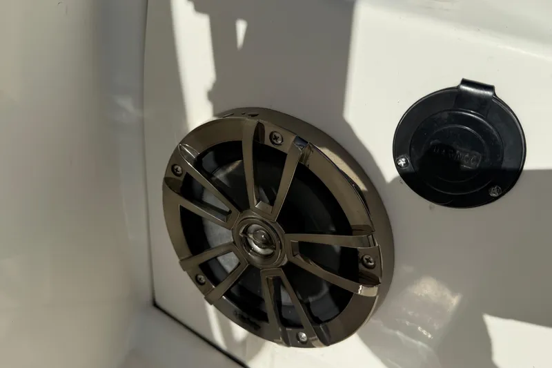 Slide: The Image of 2018 Boston Whaler 170 Super Sport boat interior with seating and motor, parked outdoors. - 9