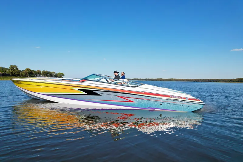 Slide: The Image of 2006 Formula 382 FASTech speedboat cruising on a calm lake under a clear blue sky. - 3