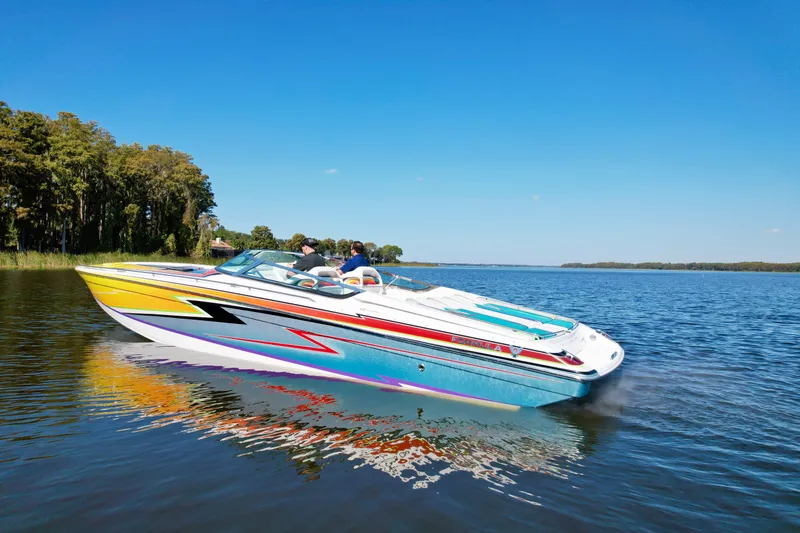 Slide: The Image of 2006 Formula 382 FASTech speedboat cruising on a serene lake under a clear blue sky. - 4