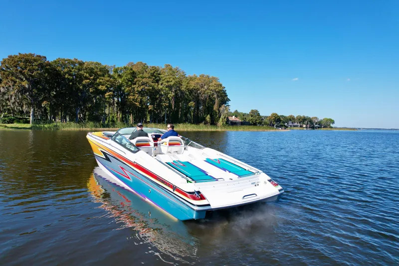 Slide: The Image of 2006 Formula 382 FASTech boat cruising on a serene lake with lush green shoreline. - 5