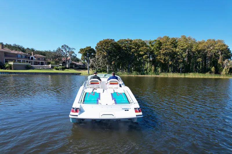 Slide: The Image of 2006 Formula 382 FASTech boat cruising on a serene lake with scenic background. - 6