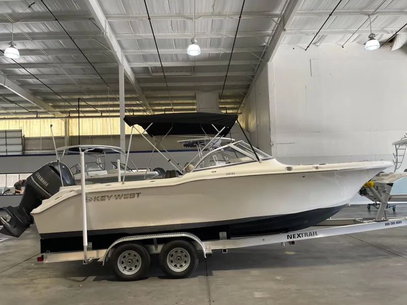 Slide: The Image of 2022 Key West 239 DFS boat on trailer, parked near a large building. - 1
