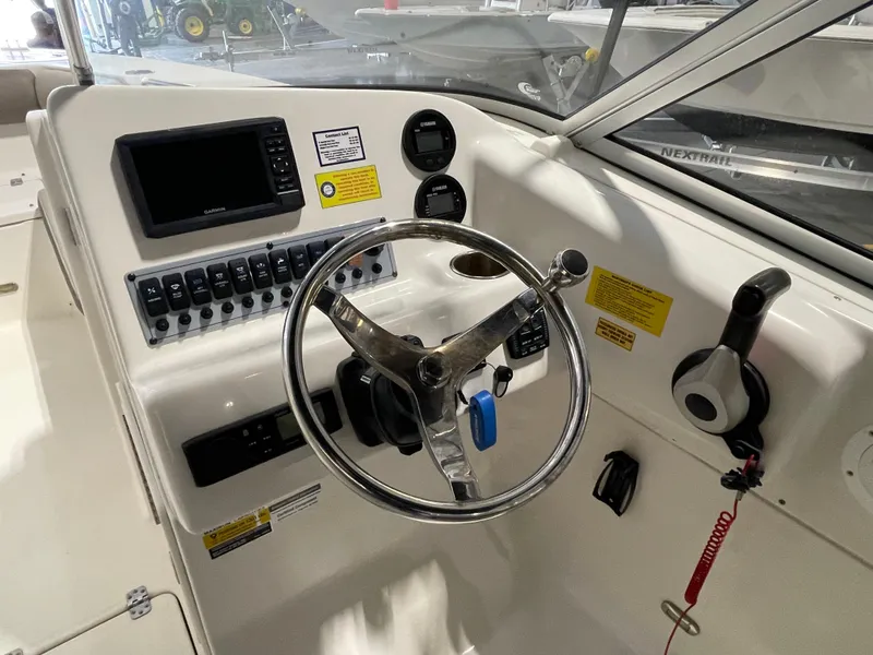 Slide: The Image of 2022 Key West 239 DFS boat dashboard with steering wheel and navigation controls. - 22