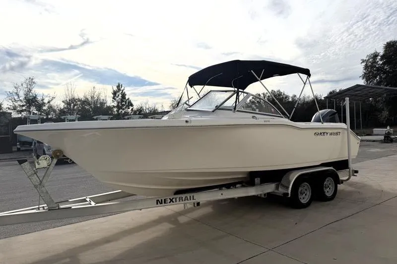 Slide: The Image of 2022 Key West 239 DFS boat on trailer, parked outdoors under cloudy sky. - 3