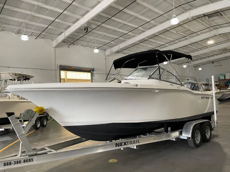 Slide: The Image of 2022 Key West 239 DFS boat on trailer with canopy, parked outdoors. - 4