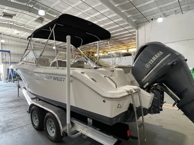 Slide: The Image of 2022 Key West 239 DFS boat with open bow seating, docked outdoors. - 6