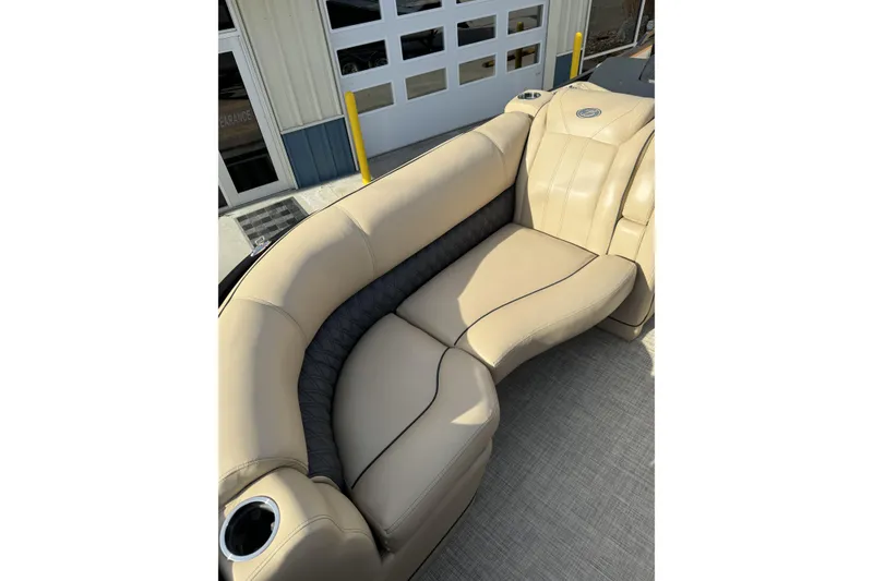 Slide: The Image of Luxurious seating on 2019 Barletta L23QC SS pontoon boat, featuring beige upholstery and cup holder. - 10