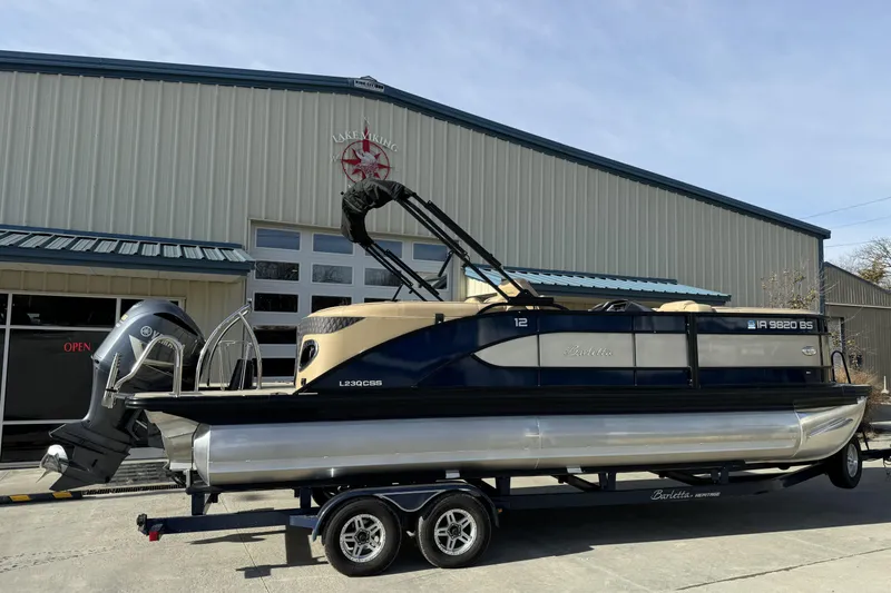 Slide: The Image of 2019 Barletta L23QC SS pontoon boat on trailer outside a large building. - 5