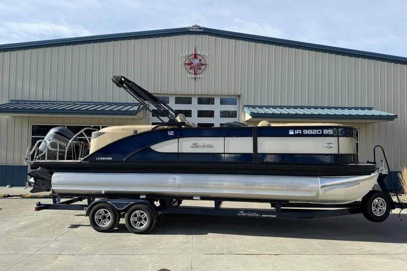 Slide: The Image of 2019 Barletta L23QC SS pontoon boat on trailer, parked outside a marine building. - 6