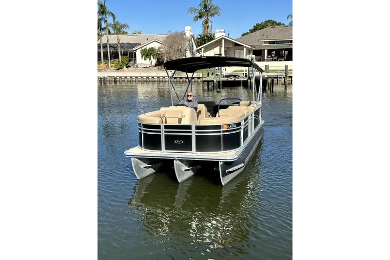 Slide: The Image of 2017 Harris Cruiser 220 pontoon boat on calm water near waterfront homes. - 18
