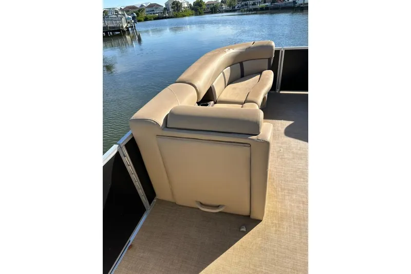 Slide: The Image of 2017 Harris Cruiser 220 pontoon boat with beige seating, docked by a serene waterfront. - 24