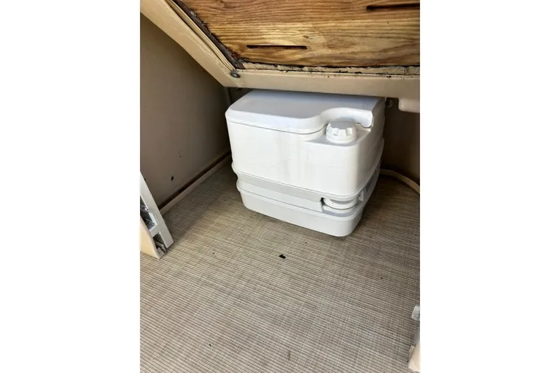 Slide: The Image of Portable toilet inside 2017 Harris Cruiser 220 boat, under wooden compartment. - 26