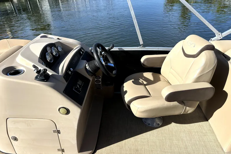 Slide: The Image of 2017 Harris Cruiser 220 boat interior with beige captain's chair and control panel. - 29