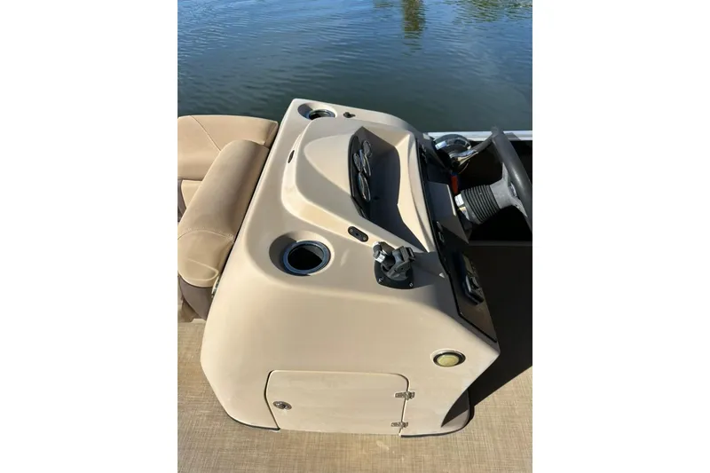Slide: The Image of 2017 Harris Cruiser 220 boat console with steering wheel and controls, on calm water. - 31
