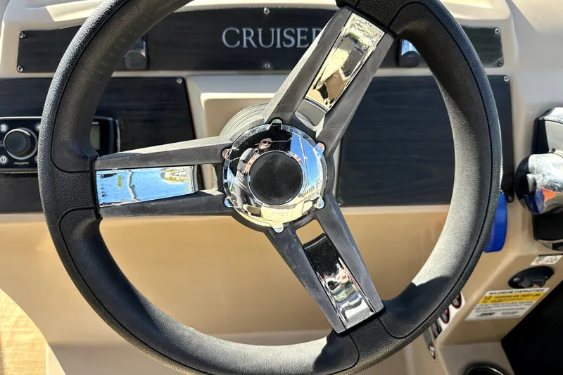 Slide: The Image of Steering wheel of a 2017 Harris Cruiser 220 boat, featuring chrome accents. - 35