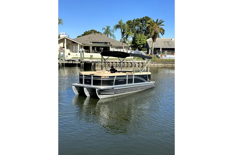 Slide: The Image of 2017 Harris Cruiser 220 pontoon boat on calm water near waterfront homes. - 5