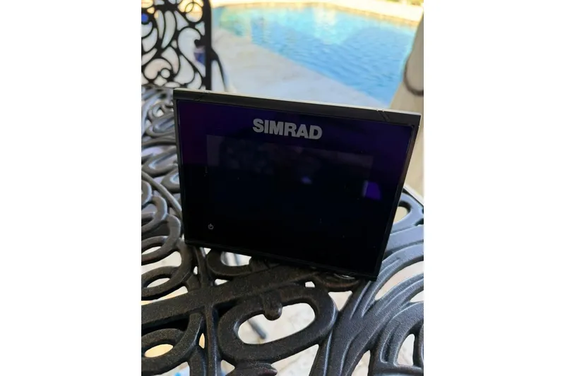 Slide: The Image of Simrad display on ornate table, near pool, for 2017 Harris Cruiser 220. - 52