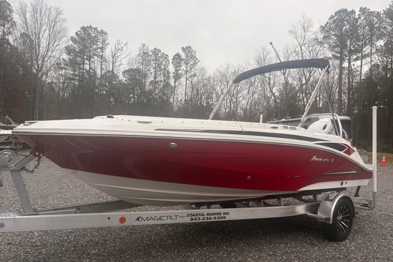 Slide: The Image of 2023 Hurricane SunDeck Sport 205 OB boat on trailer, red and white design, outdoor setting. - 15