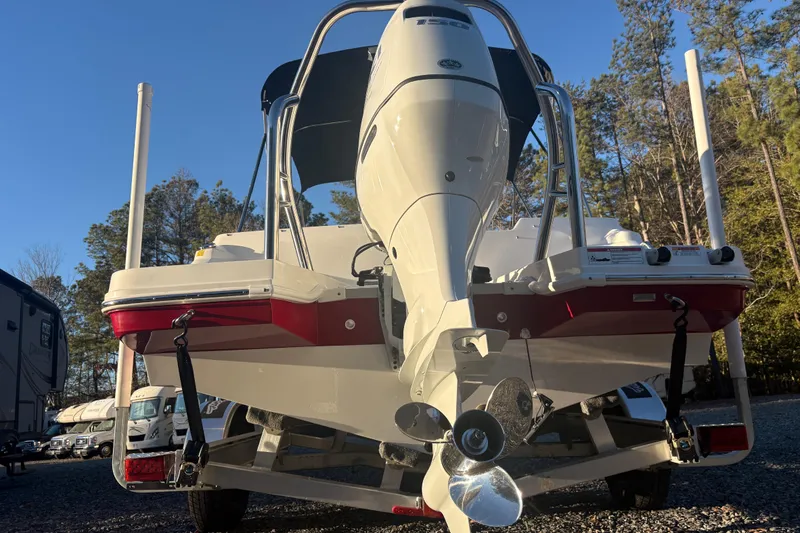 Slide: The Image of 2023 Hurricane SunDeck Sport 205 OB boat, rear view with outboard motor, parked outdoors. - 2