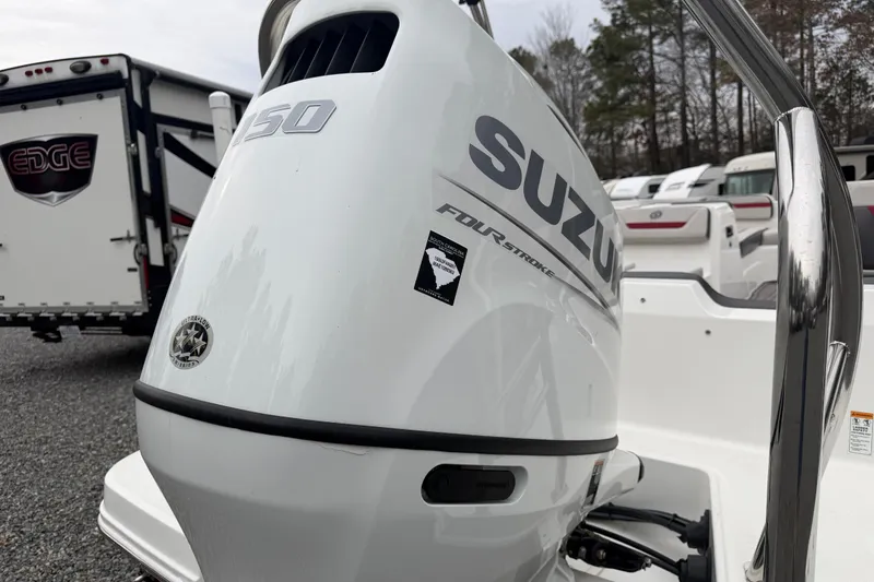 Slide: The Image of 2023 Hurricane SunDeck Sport 205 OB with Suzuki outboard motor in a boatyard setting. - 32