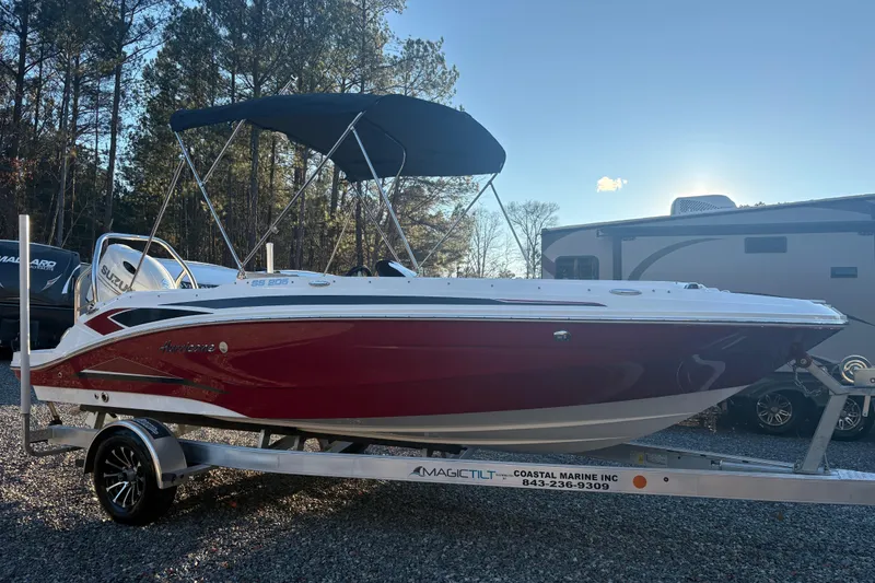 Slide: The Image of 2023 Hurricane SunDeck Sport 205 OB boat on trailer, red hull, parked outdoors. - 4