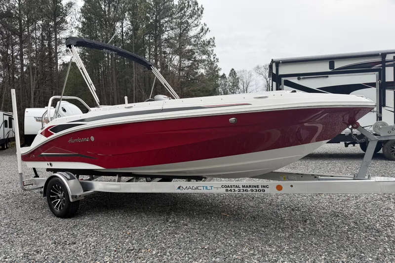 Slide: The Image of 2023 Hurricane SunDeck Sport 205 OB boat on trailer, red and white design, parked outdoors. - 41