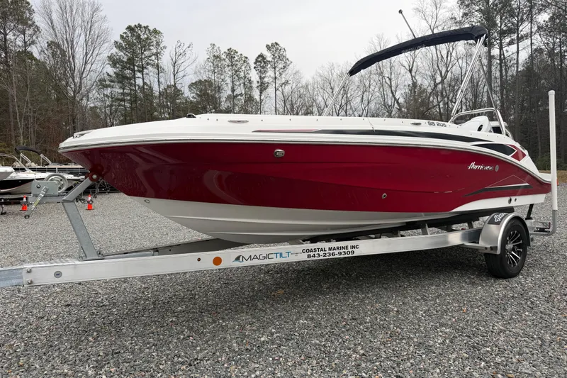 Slide: The Image of 2023 Hurricane SunDeck Sport 205 OB boat on trailer, red and white design, parked outdoors. - 45