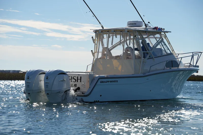 Slide: The Image of 2023 Grady-White Marlin 300 boat on water, featuring dual Yamaha engines. - 12