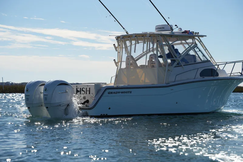 Slide: The Image of 2023 Grady-White Marlin 300 boat cruising on water with twin Yamaha engines. - 13