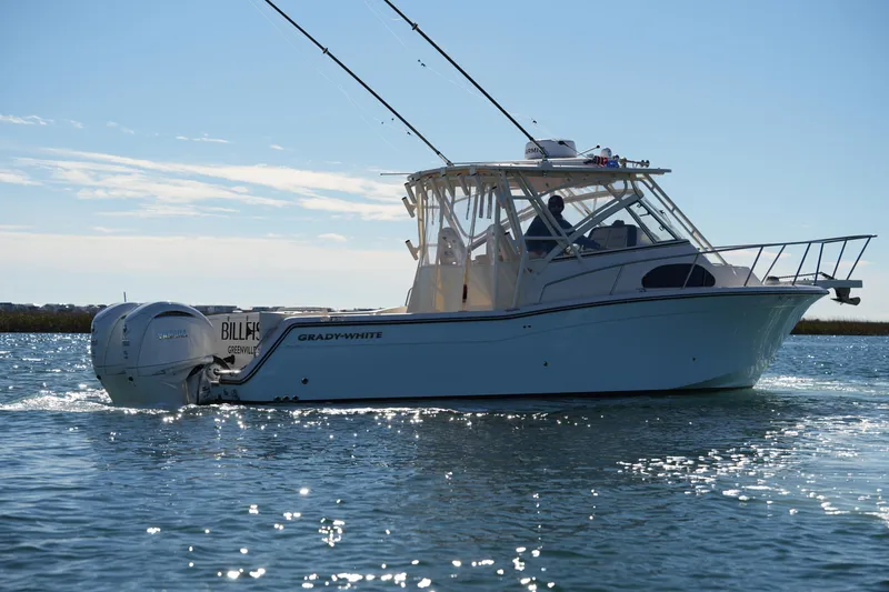 Slide: The Image of 2023 Grady-White Marlin 300 boat cruising on calm waters under a clear sky. - 15