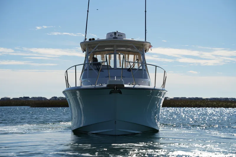 Slide: The Image of 2023 Grady-White Marlin 300 boat on sparkling water, front view. - 24