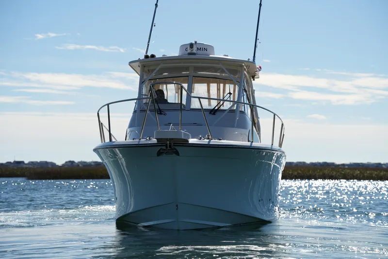 Slide: The Image of 2023 Grady-White Marlin 300 boat on water, front view, sunny day. - 25