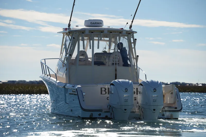 Slide: The Image of 2023 Grady-White Marlin 300 boat on water, featuring dual engines and Garmin equipment. - 3