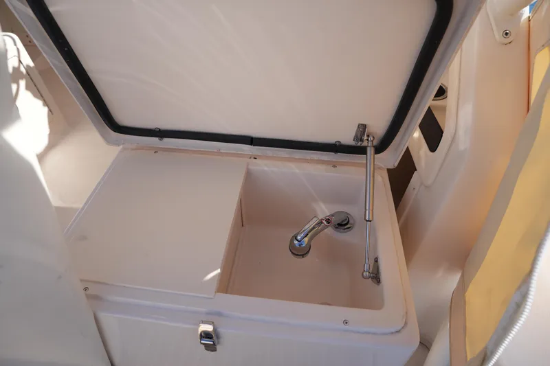 Slide: The Image of 2023 Grady-White Marlin 300 boat sink with open lid and faucet. - 35
