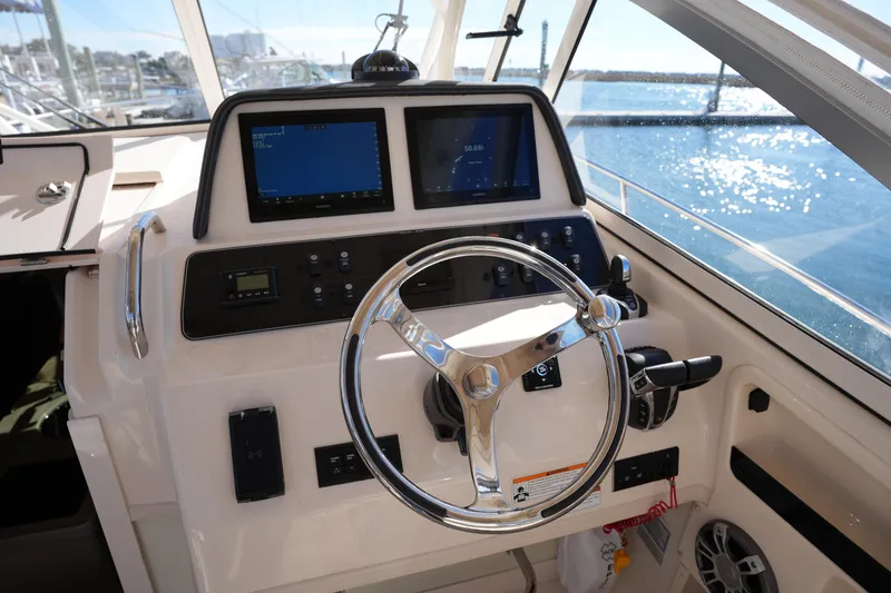 Slide: The Image of 2023 Grady-White Marlin 300 helm with dual screens and steering wheel. - 41