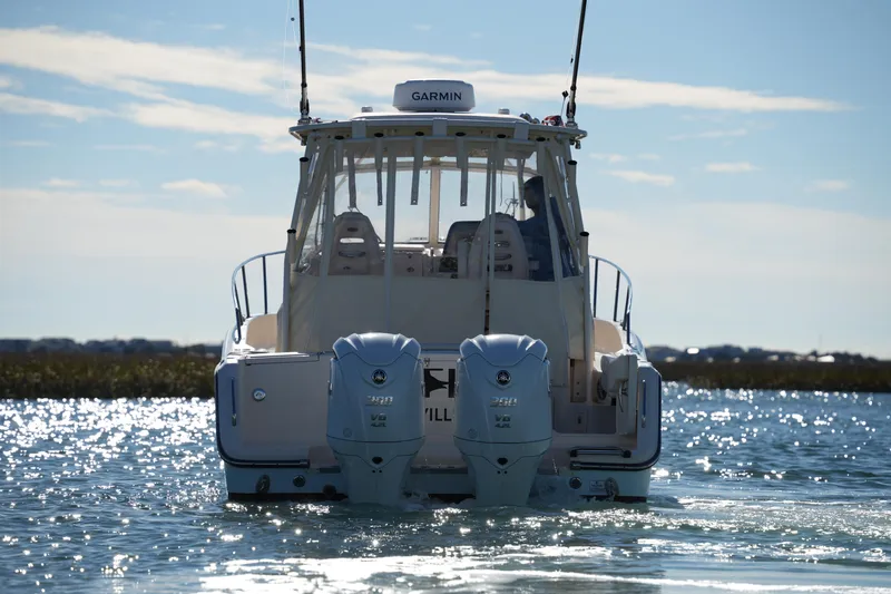 Slide: The Image of 2023 Grady-White Marlin 300 boat on water, rear view with dual engines. - 5